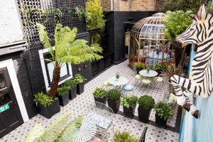a patio with plants and tables and a zebra statue at Blakes Hotel in London