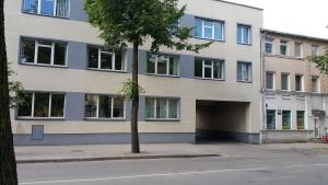 un edificio con un albero di fronte di Šiauliai Centre Apartment a Šiauliai