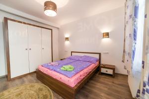 クルジュ・ナポカにあるMeda Apartmentsのベッドルーム1室(紫色のベッド1台付)