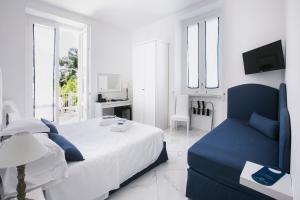 a bedroom with a bed and a blue couch at Hotel Crawford in Sant'Agnello