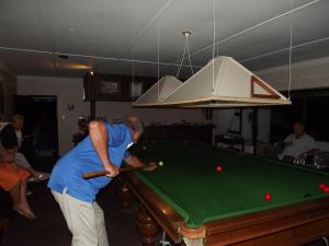 a man playing pool with a cue on a pool table at Stroke-One-Inn in Umkomaas