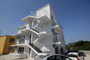 een wit gebouw met trappen aan de zijkant bij Apartments Victoria in Sutomore