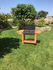 a grill sitting on a bench in the grass at Casa Vacanze Agriturismo Cilone in Ragusa