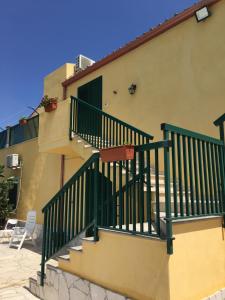 a building with a staircase with green railings at Casa Vacanze Agriturismo Cilone in Ragusa