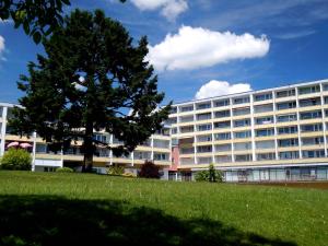 ein großes weißes Gebäude mit einem Baum davor in der Unterkunft Ferienzentrum Bodensee in Oberteuringen