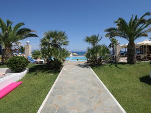 a pathway leading to a resort with palm trees and a beach at Marina Sands in Agia Marina Nea Kydonias