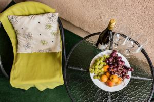 een glazen tafel met een fruitschaal en een fles wijn bij Vági Apartment in Sárvár