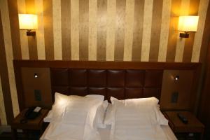 a bed with a brown headboard and two night stands at Hotel Bellevue Saint-Lazare in Paris