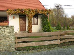 a house with a wooden fence in front of it at Patakparti Apartman in Bozsok