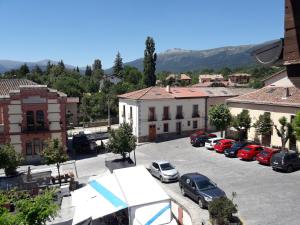 a parking lot with cars parked in a town at PLAZA DE LA VILLA 24 in Rascafría