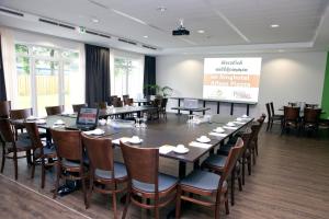 una sala de conferencias con una mesa grande y sillas en Ringhotel Alfsee Piazza, en Rieste