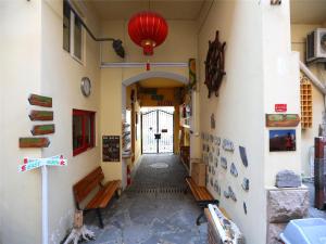 Wheat Youth Hostel Qingdao في تشينغداو: ممر لمبنى به فانوس احمر