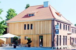 un grand bâtiment en bois avec un toit rouge dans l'établissement Alte Heimat, à Berge