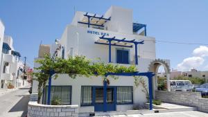 um edifício branco com acabamento azul numa rua em Hotel Rea em Naxos Chora