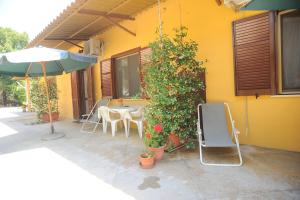 eine Terrasse mit einem Tisch, Stühlen und einem Sonnenschirm in der Unterkunft Agriturismo La Giannottola in Aprilia