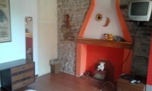 ein Wohnzimmer mit einem Kamin und einem TV in der Unterkunft B&B Il Conventino in Brisighella