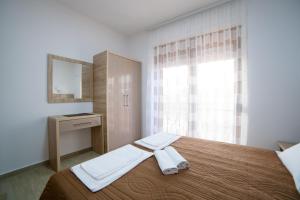 a bedroom with a bed with two towels on it at Kollari Apartments in Ulcinj