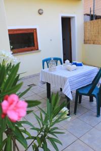 a white table and two blue chairs and a table with at Guest House Li Minnanni in Olbia +14 photos