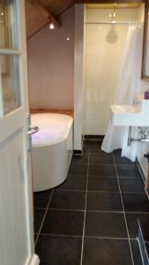 a bathroom with a tub and a sink at Luxe kamer Cadzand in Cadzand