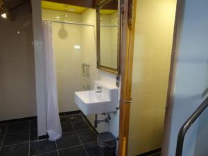 een badkamer met een wastafel en een spiegel bij Luxe kamer Cadzand in Cadzand