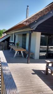 een picknicktafel op een terras voor een gebouw bij Luxe kamer Cadzand in Cadzand