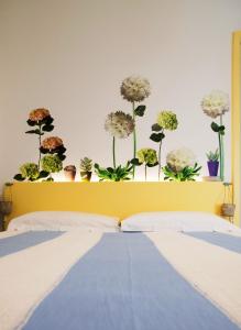 a bedroom with a bed with flowers on the wall at Emiolia in Milazzo