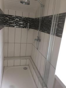 een douche in een wit betegelde badkamer bij Le coup de coeur in Coincy