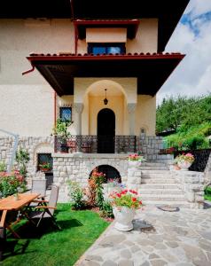 a house with a patio with a stone fireplace at Vila Leonida - RESORT LEONIDA in Buşteni