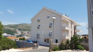 a white apartment building with a hill in the background at Sweet Dream 2 in Dubrovnik