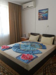 a large bed with two blankets on top of it at Primorsko Apartments in Primorsko
