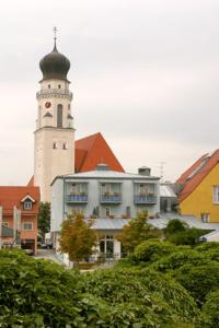 um edifício com uma torre de relógio em cima em Altstadthotel Bad Griesbach em Bad Griesbach