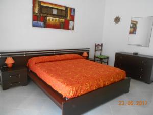 1 dormitorio con 1 cama con edredón de naranja en Casa Paradiso, en Brindisi
