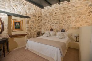 a bedroom with a bed in a stone wall at Kritikies in Pitsidia