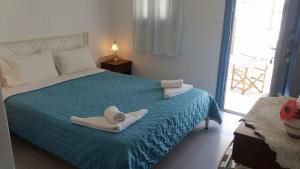 1 dormitorio con 1 cama con toallas en Artemis Rooms, en Chora Folegandros