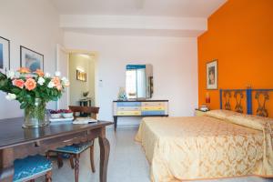 um quarto com uma cama e uma mesa com flores em Emiolia em Milazzo