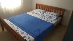 a bed with blue and white sheets and pillows at Apartments Diva in Dobra Voda