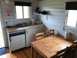 a small kitchen with a wooden table and a table and chairs at Keldunes in Garður