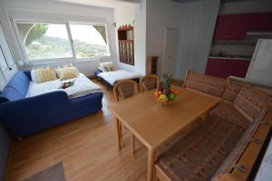 a living room with a table and a blue couch at Lloret Apartments in Lloret de Mar