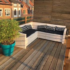 a wooden deck with two beds on a balcony at Maison d'O in Ostend