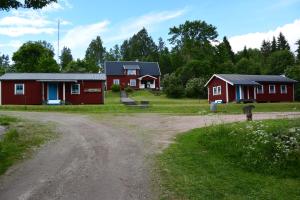 a group of red cabins on a dirt road at Mieps Huset Dalarna Holiday in Kullen