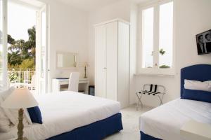 a bedroom with two beds and a desk with a chair at Hotel Crawford in Sant'Agnello