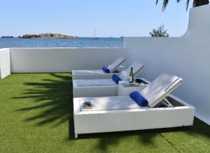 - une chambre avec deux chaises et une vue sur l'eau dans l'établissement Enkala Apartamentos, à Ibiza