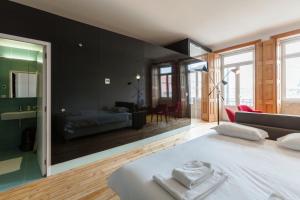 une chambre avec un grand lit blanc et un salon dans l'établissement Go2oporto - Fontainhas Apartments, à Porto