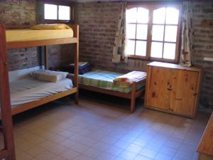 Habitación con 2 literas y mesa. en Puma Hostel en San Martín de los Andes