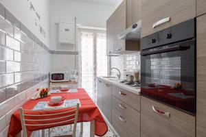 ローマにあるLa casa di Giuliaのキッチン(テーブル、赤いテーブルクロス付)