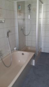 a bathroom with a tub and a shower and a sink at Ferienwohnung Baur in Tussenhausen +11 photos