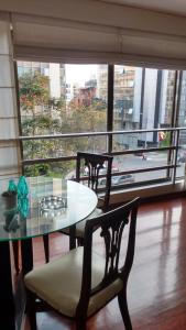 a table and chairs in a room with a large window at Apartamentos Amoblados de 1 Y 2 dormitorios in Lima