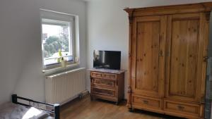 Habitación con TV en un tocador y ventana en Casa Mia, en Kassel