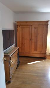 Habitación con TV y armario de madera. en Casa Mia, en Kassel