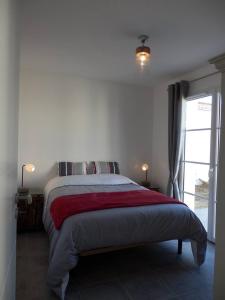 サン・ピエール・ドレロンにあるAu bois flottéのベッドルーム1室(赤毛布付きの大型ベッド1台付)